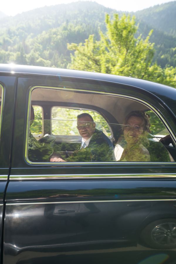 Les mariés à l’arrière de la voiture ancienne
